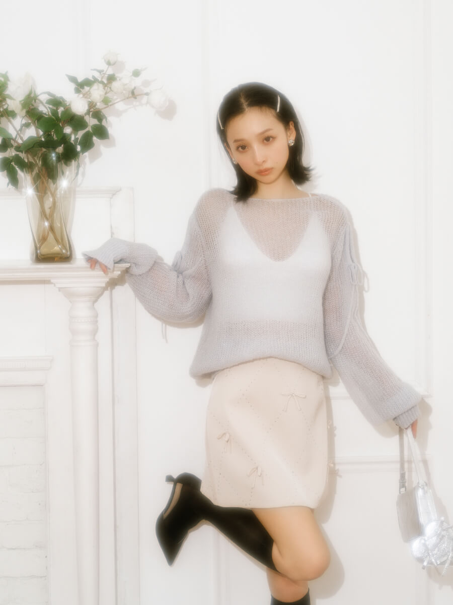 モヘアシアーニットトップス・【WEB限定カラー】[L.B CANDY STOCK]ビジューリボンミニスカート・サテンストラップパンプス・シアーレースハイソックス・リボンバレッタセット・ハートイヤリング・ミニリボンバッグを着用した女性