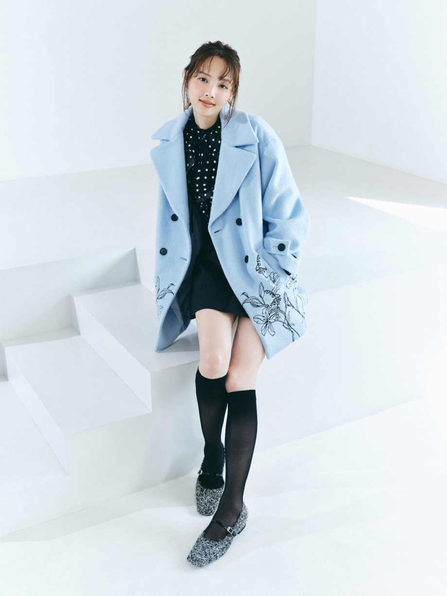 エンブロイダリーコクーンコート＆クレープラッフルフリルブラウス＆ボンディングミニスカート＆シアーレースハイソックス＆ストラップ付フラットパンプス＆LBロゴイヤリングを着た女性