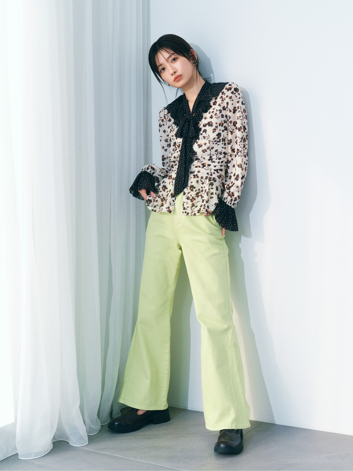 ベージュのバイカラープリントボウタイブラウス・イエローのストレッチフレアデニムパンツ・黒のTストラップブローグシューズ・ブラウンのヴィンテージモチーフイヤリングの着用例