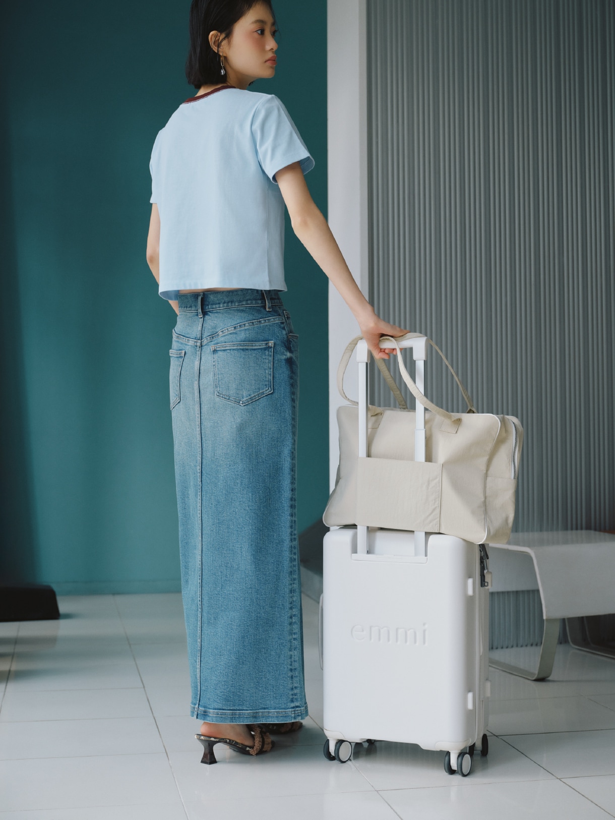 ブルーのクールタッチコンパクトTシャツ・ライトブルーのデニムロングスカート・アイボリーのボストンバッグ・チャーム・ピアス・ブラウンのフリンジリボンミュールサンダルを合わせたコーディネート