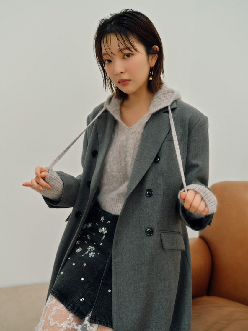 ダブルブレストロングコート・[L.B CANDY STOCK]ビジューデニムミニスカート・ケーブルニットフーディー・バイカーブーツ・レースレイヤードレースラップスカート・ボールフープピアスを着用した女性