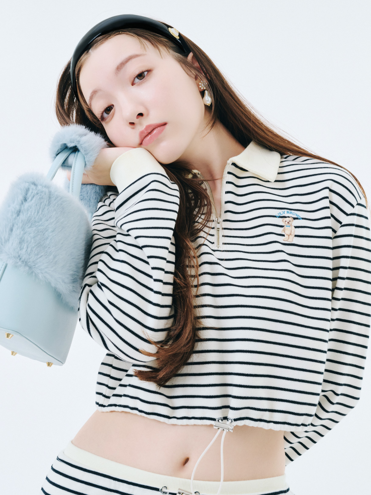 Lily Bearハーフジップクロップドスウェット・ペンシルスウェットスカート・3バックルミドルブーツ・ヴィンテージモチーフカチューシャ・バリエーションパールピアス・エコファーコンビ2wayトートを着用した女性